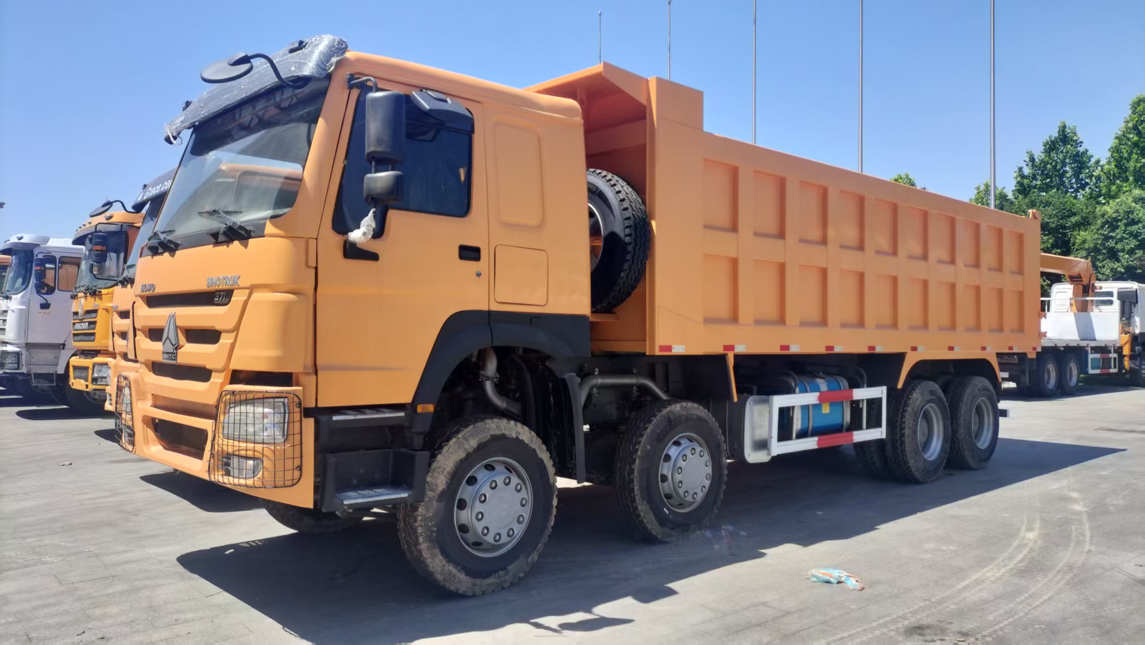 Camión volquete pesado HOWO 8×4 de 371 CV, con cuatro volquetes delanteros y ocho traseros, para transporte de minas, lodo y áridos.