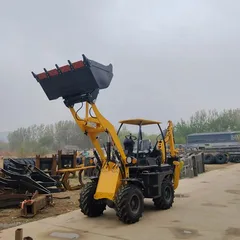 Compact diesel backhoe loader working on narrow rural road construction site
